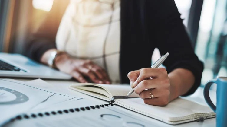 someone writing in a planner